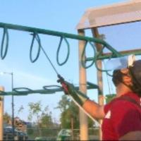man sanitizing playground equipment